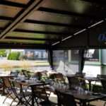 Attico fixed motorized awning with durable aluminum frame and high-quality vinyl fabric, designed for commercial outdoor spaces.