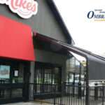 Attico fixed motorized awning with durable aluminum frame and high-quality vinyl fabric, designed for commercial outdoor spaces.