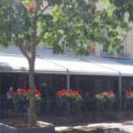 Attico fixed motorized awning with durable aluminum frame and high-quality vinyl fabric, designed for commercial outdoor spaces.