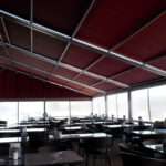 Attico fixed motorized awning with durable aluminum frame and high-quality vinyl fabric, designed for commercial outdoor spaces.
