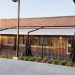 Attico fixed motorized awning with durable aluminum frame and high-quality vinyl fabric, designed for commercial outdoor spaces.