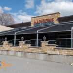 Attico fixed motorized awning with durable aluminum frame and high-quality vinyl fabric, designed for commercial outdoor spaces.