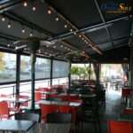Attico fixed motorized awning with durable aluminum frame and high-quality vinyl fabric, designed for commercial outdoor spaces.