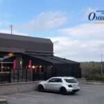Attico fixed motorized awning with durable aluminum frame and high-quality vinyl fabric, designed for commercial outdoor spaces.