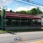 Attico fixed motorized awning with durable aluminum frame and high-quality vinyl fabric, designed for commercial outdoor spaces.