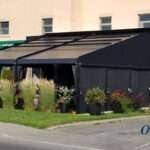 Attico fixed motorized awning with durable aluminum frame and high-quality vinyl fabric, designed for commercial outdoor spaces.